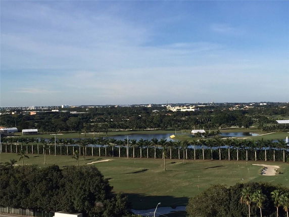 Wide angle view of landscaped parkland with water bodies and trees.