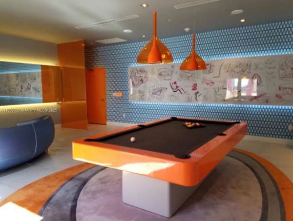 Indoor recreation room with a billiards table and colorful decor.