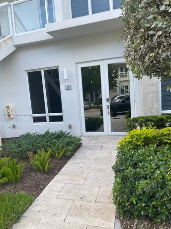 Front view of a modern two-story house with glass doors and windows.
