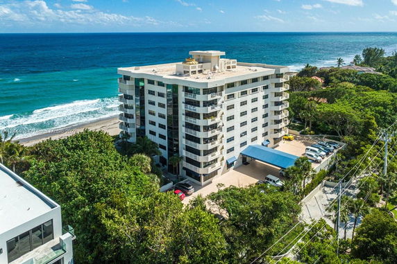 View of a multi-story apartment building near the ocean.