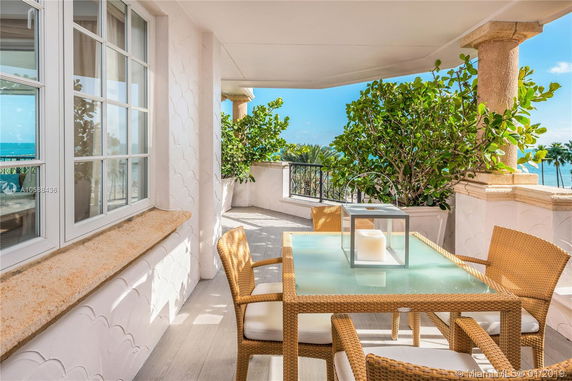 View from a patio with a table and chairs overlooking the ocean.