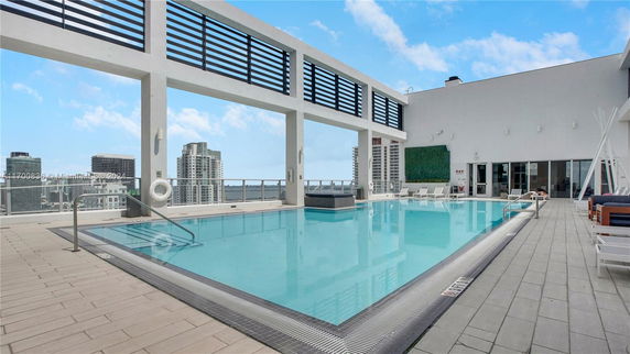 Rooftop view featuring a modern swimming pool with cityscape in the background.