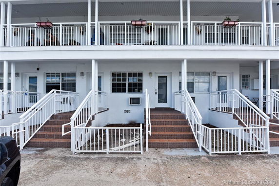 Front view of a two-story apartment building with balconies.