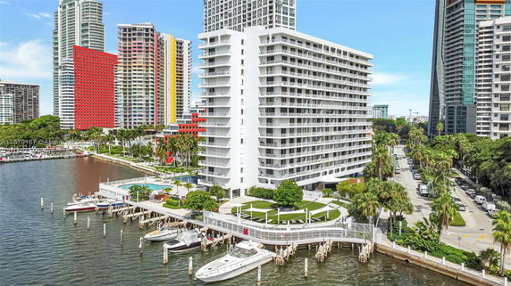 Front view of a multi-story waterfront building with balconies.