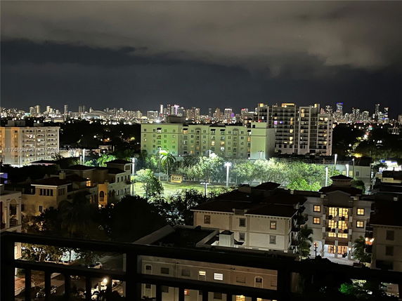Nighttime panoramic view of cityscape with illuminated buildings.