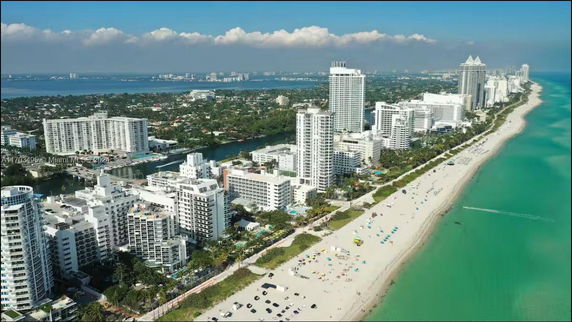 Panoramic view of a coastal city with high-rise buildings and a beach.