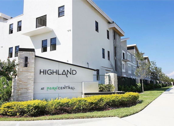 Front view of a multi-story residential building with a sign reading 'Highland at Park Central'.