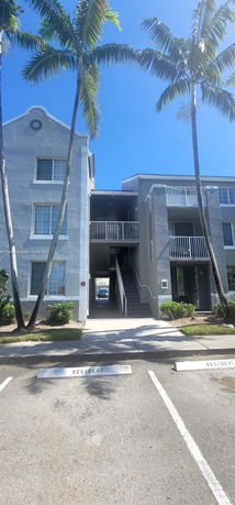Front view of a multi-story apartment building with stair access and balconies.