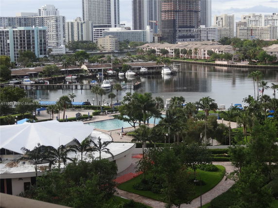 Panoramic view of a waterfront area with residential buildings and boats.