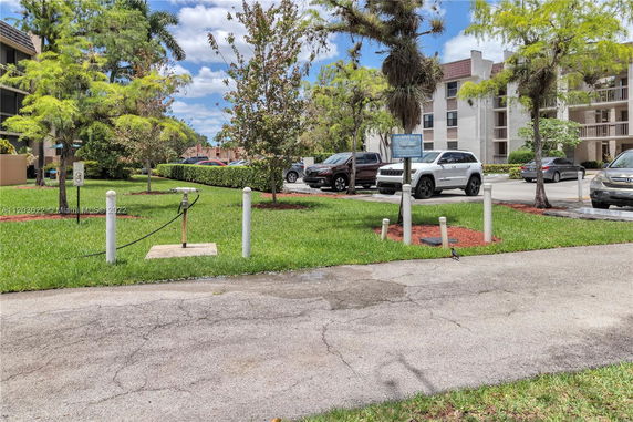 Outdoor parking area next to a building with several parked vehicles.