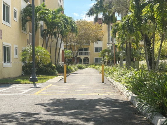 Front view of a multi-story residential building with yellow exterior and balconies.