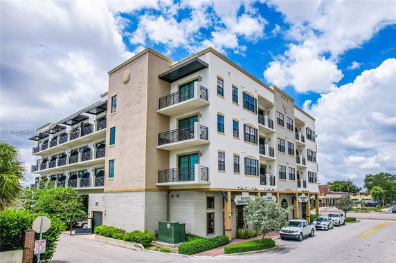 Front view of a multi-story apartment building with balconies.