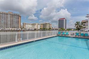 Outdoor swimming pool with city buildings in the background.