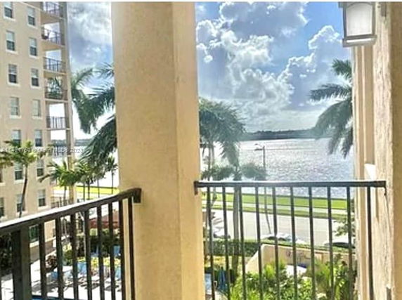 View from a balcony overlooking water and nearby buildings.