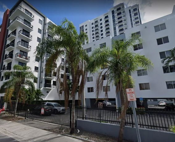 Front view of a multi-story apartment building with balconies.
