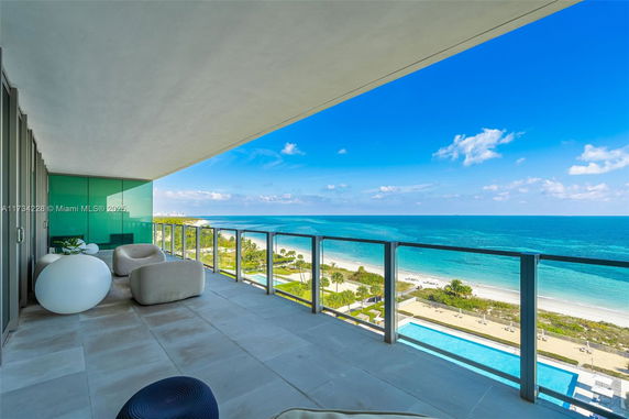 Balcony with ocean view and modern seating.