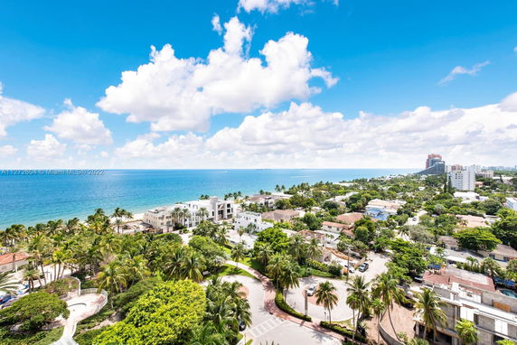 Panoramic view of a coastal area with residential buildings and ocean in the background.