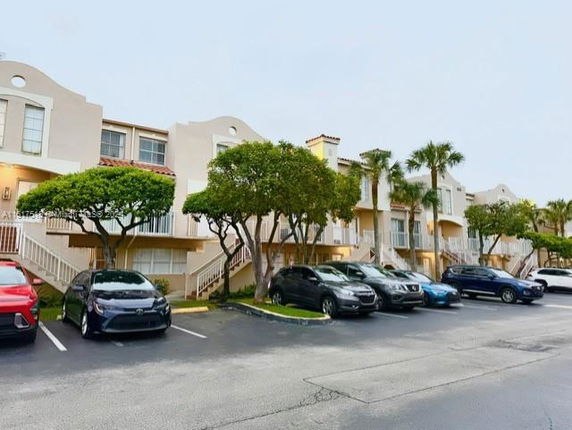 Front view of a multi-story residential building with staircases and arched windows.