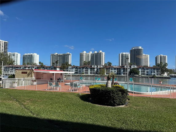 Outdoor swimming pool area with surrounding residential and high-rise buildings.