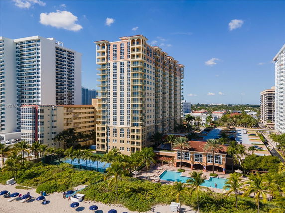 Front view of a multi-story beachfront building with a swimming pool area.