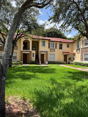 Front view of a two-story residential building with a red-tiled roof and beige walls.