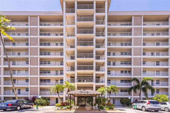 Front view of a multi-story building with balconies and an entrance canopy.