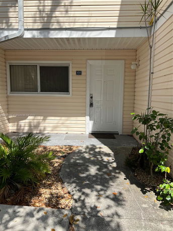 Front view of a house with a white door and a small window beside it.