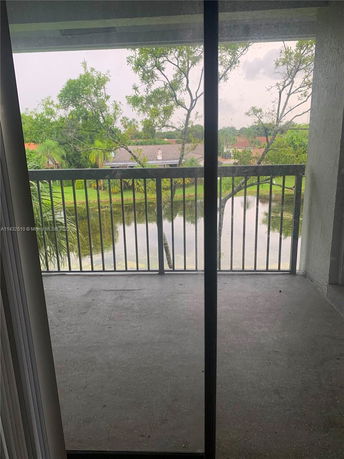 View from a balcony overlooking trees and a pond.