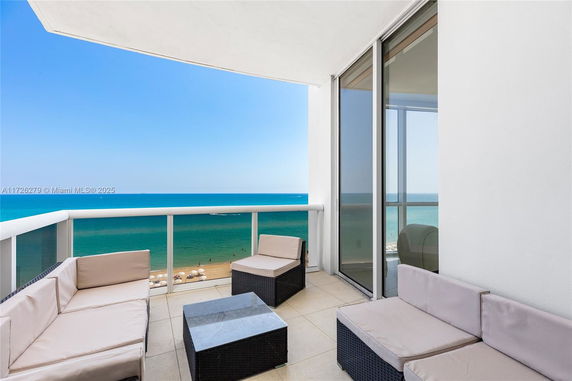 Balcony with outdoor seating offering a wide view of the ocean.
