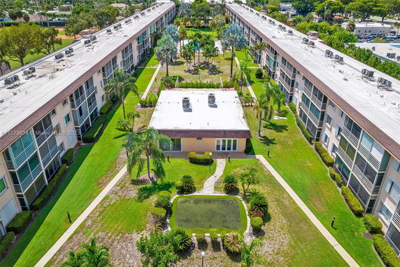 Aerial view of a residential complex with long buildings and greenery.