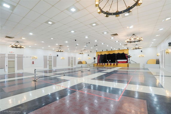 Large indoor hall with stage and sports net setup.
