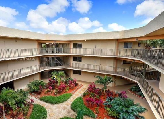 View of a multi-story building with open corridors and landscaped central courtyard.