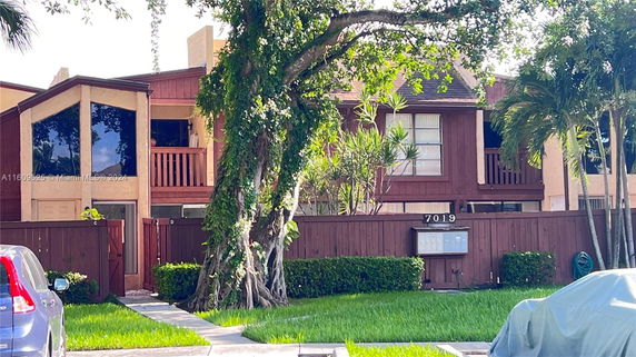 Front view of a two-story house with wooden accents and a balcony.
