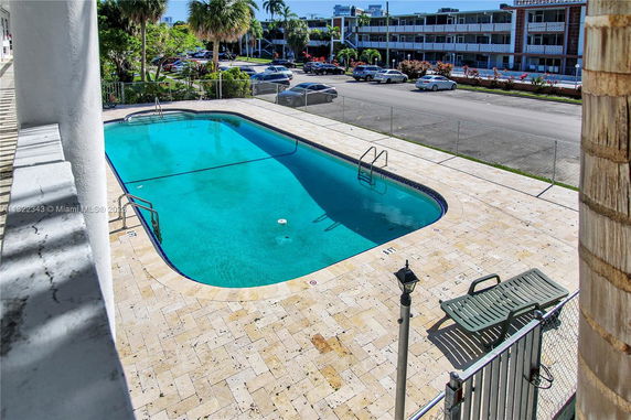 Outdoor swimming pool with surrounding patio area and street view.