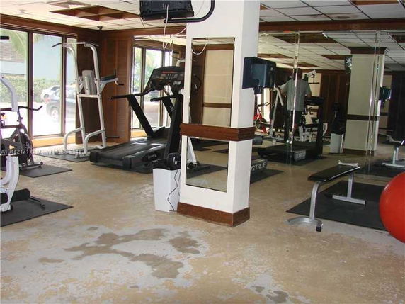 Indoor gym area with exercise equipment and mirrors.