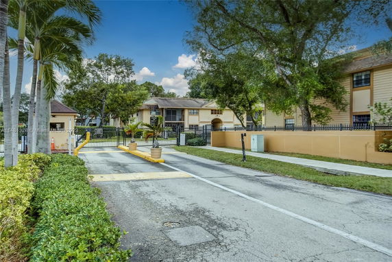 Front view of a gated residential complex with two-story buildings.