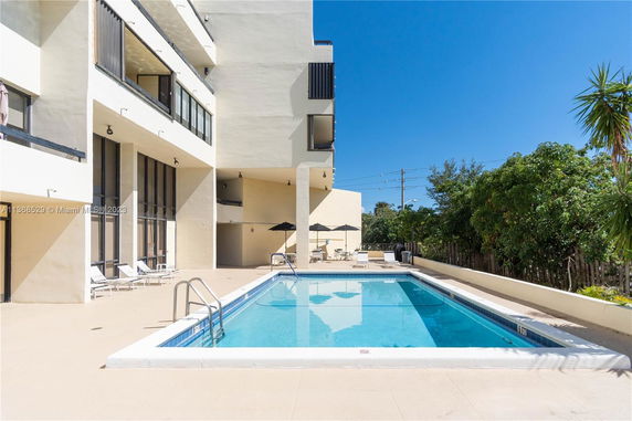 Outdoor swimming pool adjacent to a multi-story building.