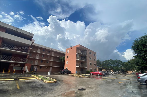 Outdoor parking area in front of a multi-story residential building.