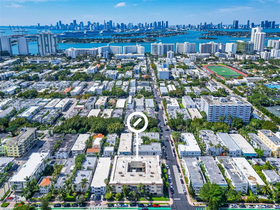 Aerial view of urban neighborhood with multiple buildings and a distant skyline.