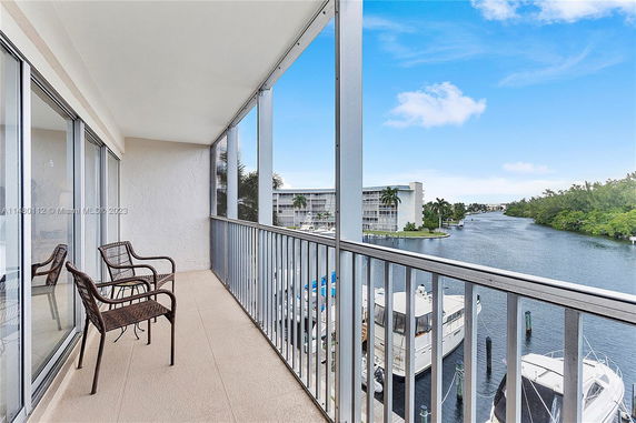View from a balcony overlooking a waterway with boats and nearby buildings.