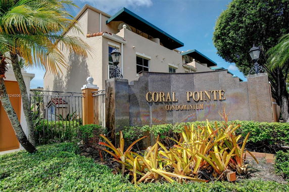 Front view of a condominium building with a sign reading 'Coral Pointe Condominium'.