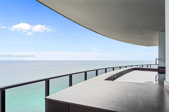 Panoramic view from a building balcony overlooking the ocean.