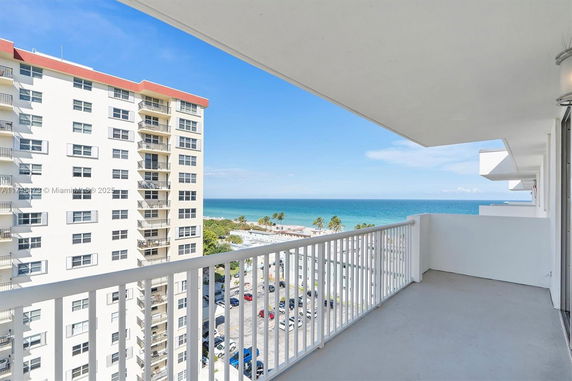 Balcony view of ocean and surrounding buildings.