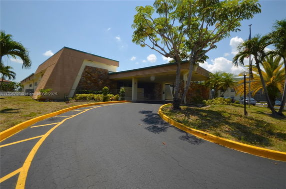 Front view of a modern building with a unique angled roof and stone accents.
