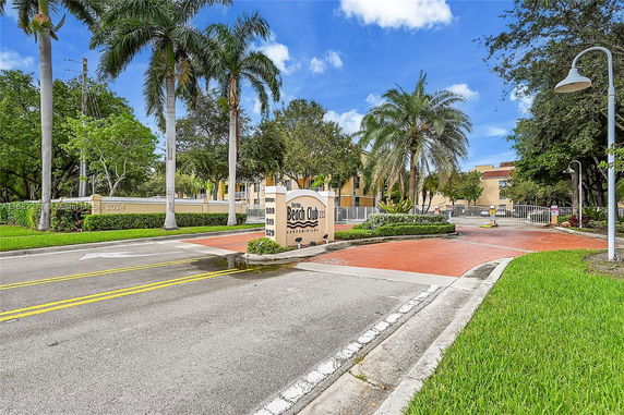 Front view of a condominium entrance with signage.