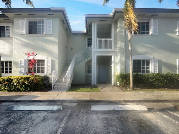 Front view of a two-story building with a central staircase and multiple windows.