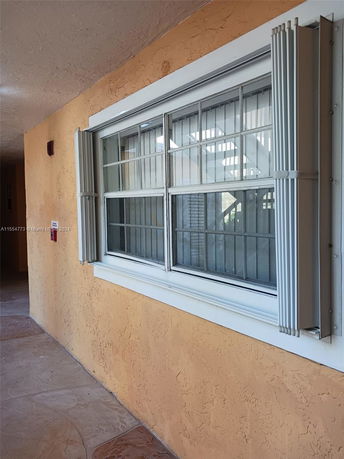 View of a window on an exterior wall with protective shutters.