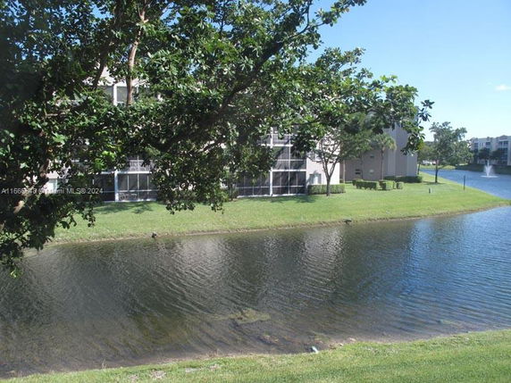 View of a body of water with buildings and greenery in the background.