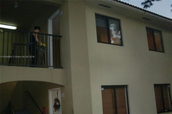 Front view of a two-story building with a balcony and windows.