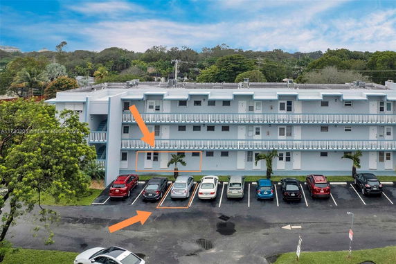 Front view of a three-story building with parking spaces in front.